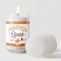 A lit pumpkin spice scented candle with its cap beside it.