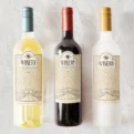 Three bottles of wine—white, red, and rosé—lined up against a light background.