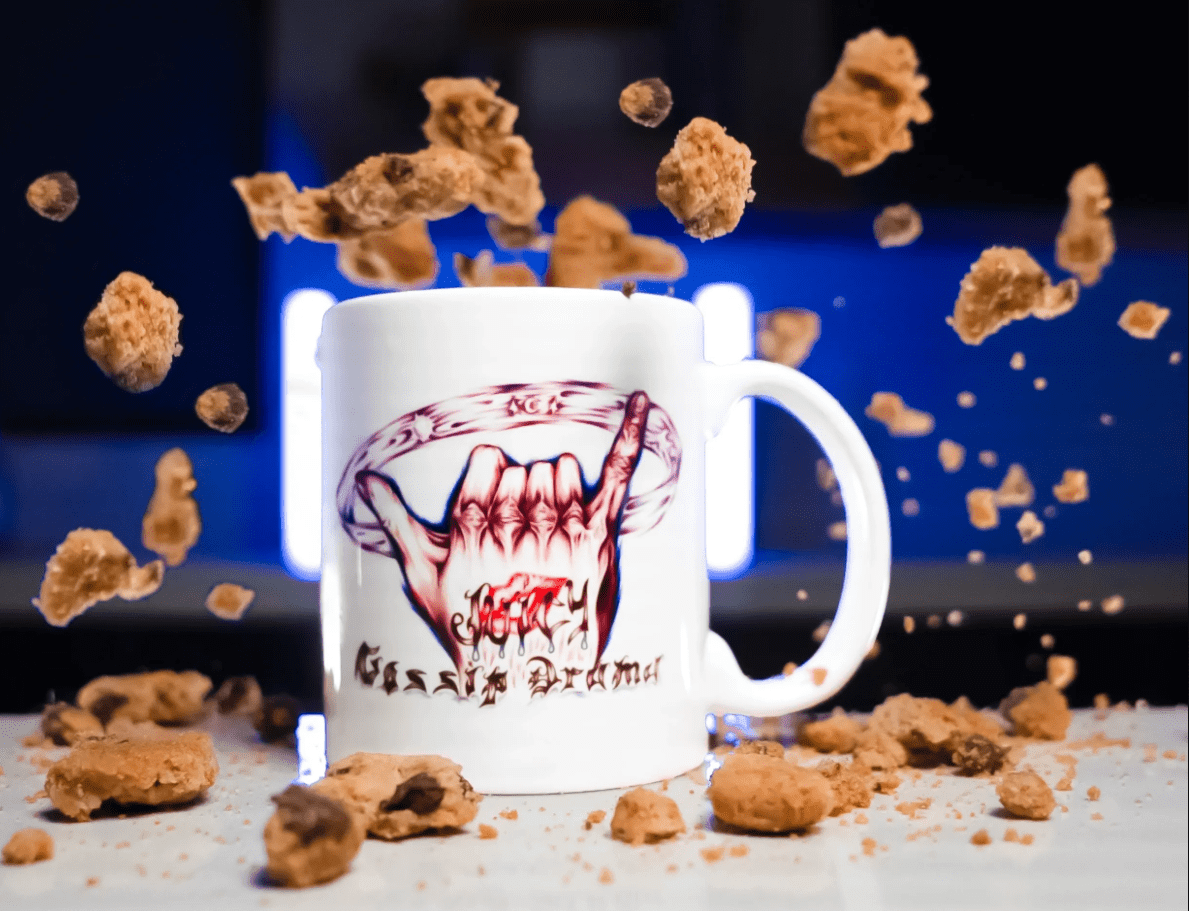 White mug featuring fanged-mouth graphic, flying cookies